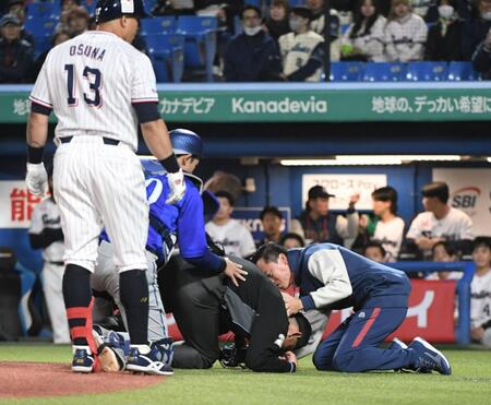 ８回、オスナが空振りしたバットが直撃し、もんどりうって倒れ込む川上球審（中央）＝撮影・佐藤厚