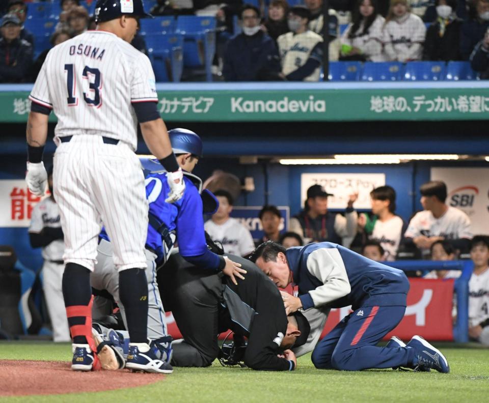 ８回、オスナが空振りしたバットが直撃し、もんどりうって倒れ込む川上球審（中央）＝撮影・佐藤厚