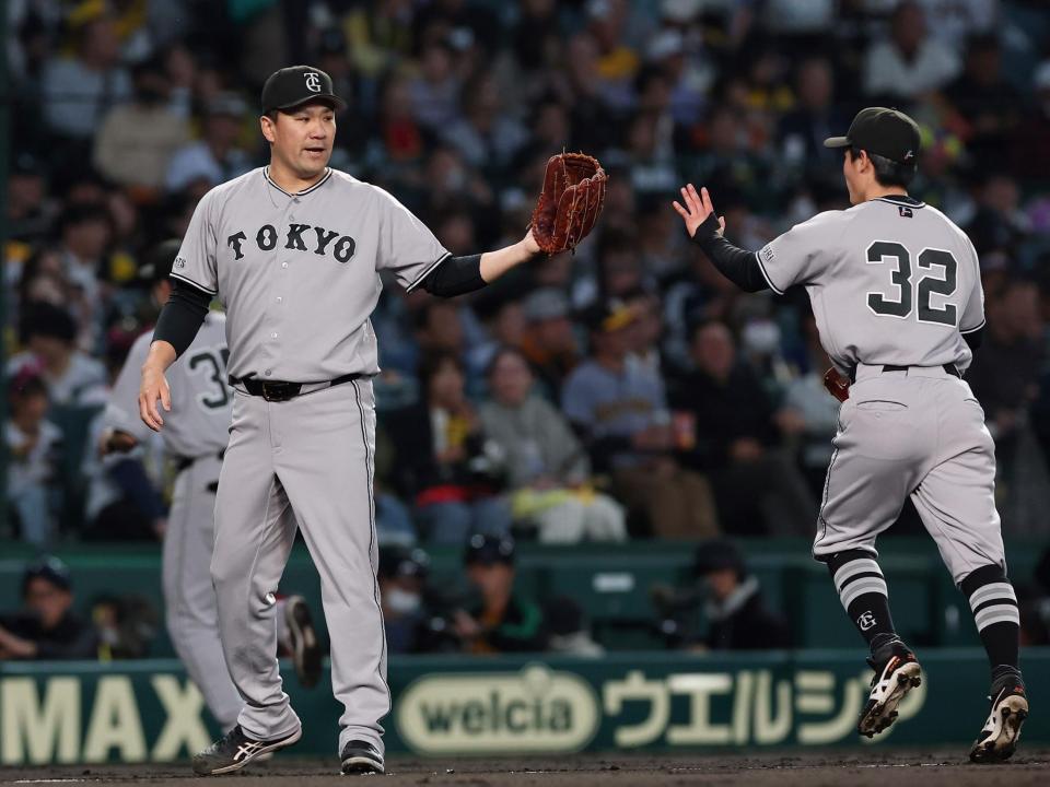 ２回を投げ終え、浦田（右）とタッチを交わす田中将（撮影・西田忠信）