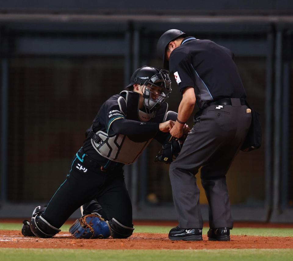 ５回、有隅球審のマスクの絡まりを手伝う田宮（撮影・中島達哉）