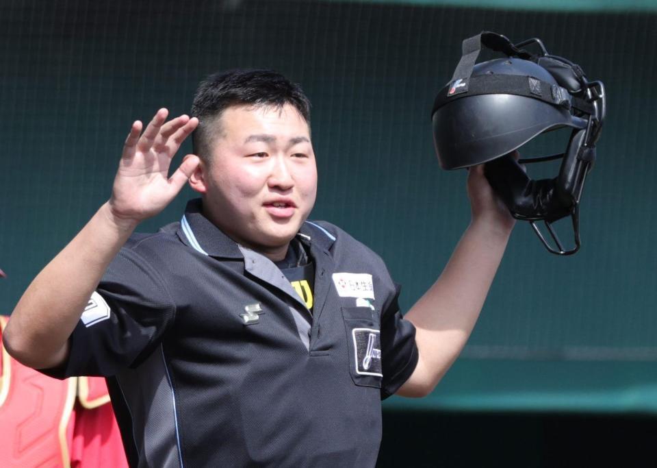 ヘルメットを手にする下村球審（撮影・坂部計介）