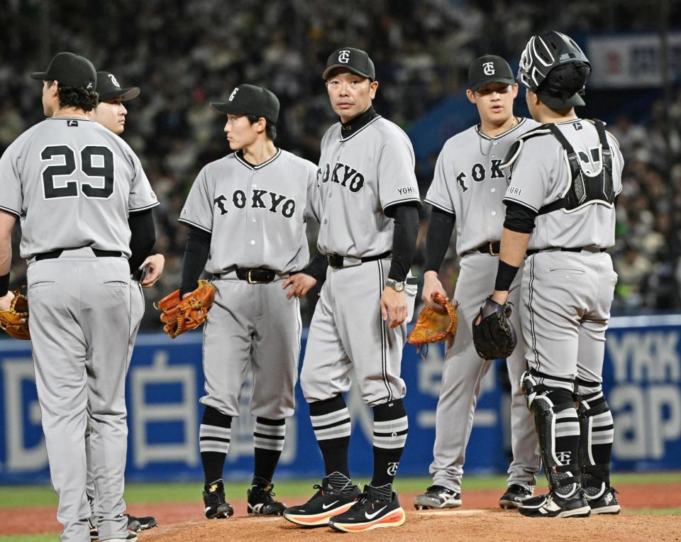 ７回、投手交代でマウンドに集まる阿部監督（中央）とナイン