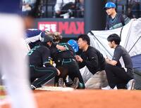 ７回、ゴロを処理し、平沢の本塁への送球が当たり、一塁でしゃがみ込む水谷（中央）＝撮影・中島達哉