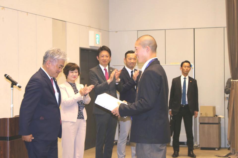 記念品を受け取る吉岡（右）