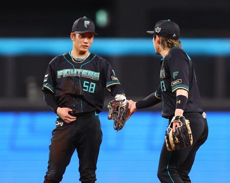 ７回、好守をみせ、水野（右）とタッチを交わす奈良間（撮影・中島達哉）