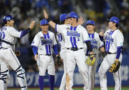 阪神に勝利し、ナインとタッチを交わす牧（中央）＝撮影・西岡正