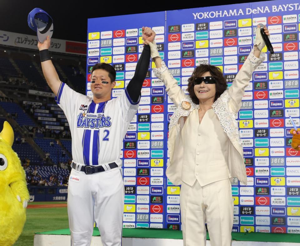 龍玄とし（右）と両手を上げる牧（撮影・西岡正）