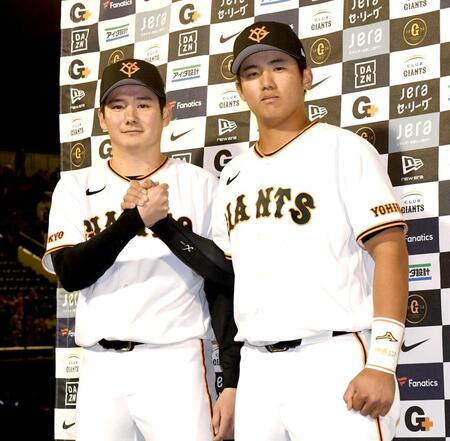 がっちりと握手する竹丸（左）と石塚（撮影・佐藤厚）