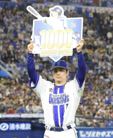 １０００試合出場を達成し、ボードを掲げる佐野（撮影・西岡正）