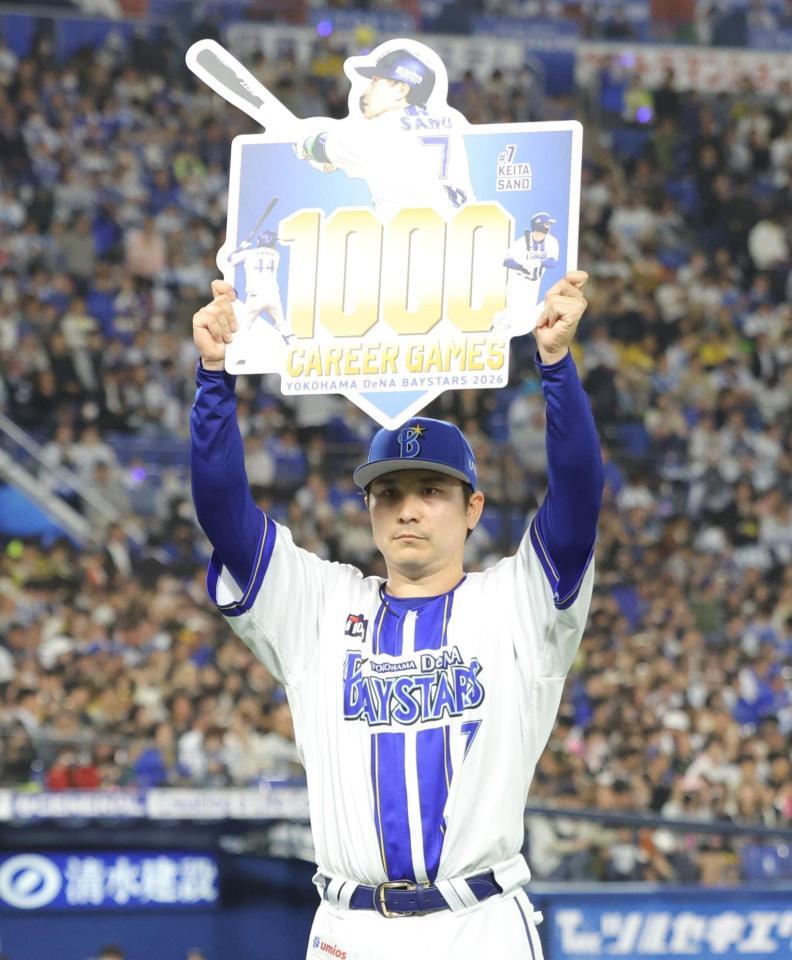 １０００試合出場を達成し、ボードを掲げる佐野（撮影・西岡正）