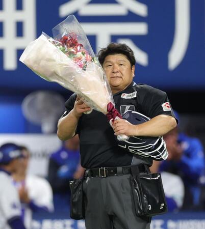 ２０００試合出場を達成し、花束を持つ敷田直人球審（撮影・西岡正）