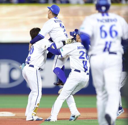 １１回、サヨナラ打を放ち、ナインに祝福される戸柱（左）＝撮影・西岡正