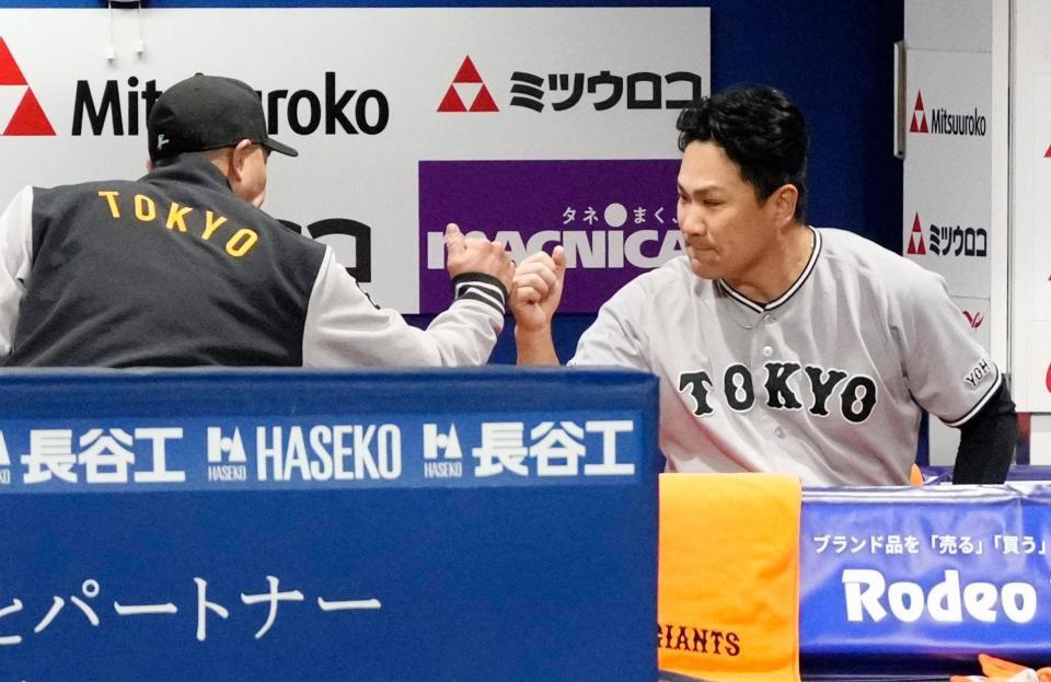 ７回途中で降板し、ベンチで阿部監督（左）とタッチを交わす田中将