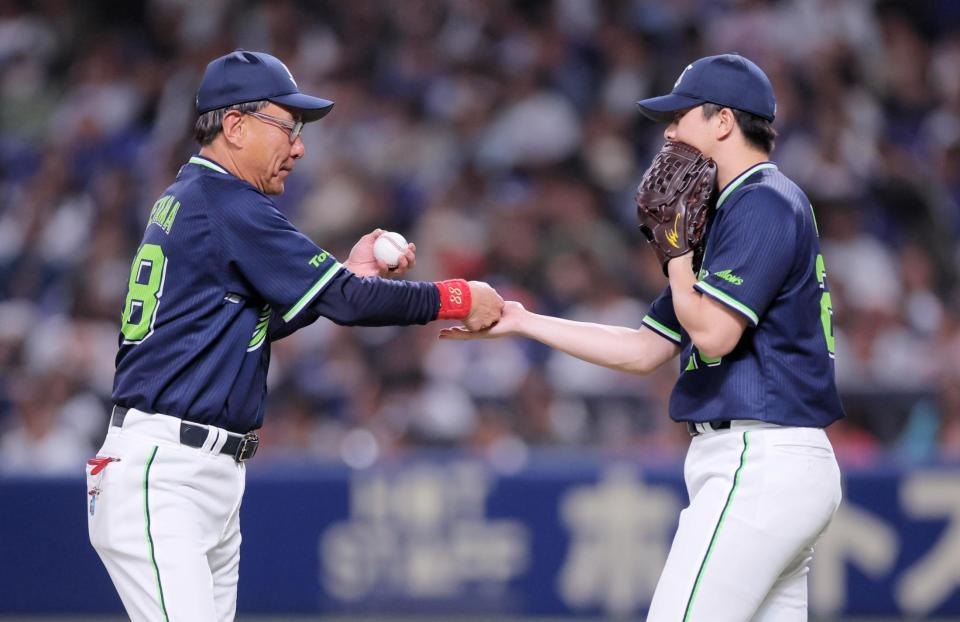 ８回、イニング途中で登板する木沢（右）にボールを手渡す池山監督