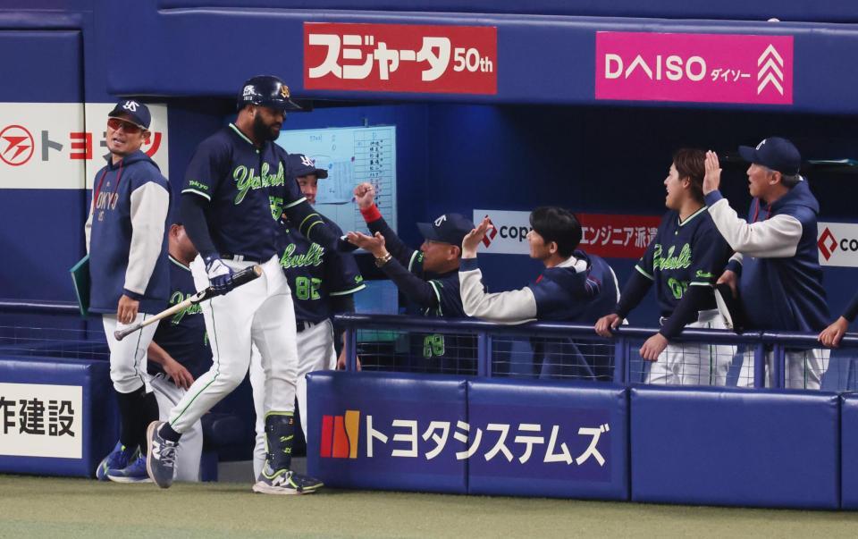 ８回、勝ち越しソロを放ったサンタナをベンチで迎える池山監督（中央）