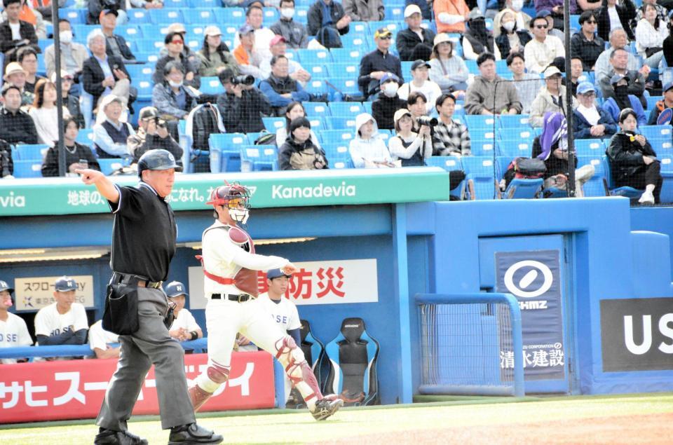 東京六大学野球で球審が捕手用のヘルメットを着用する