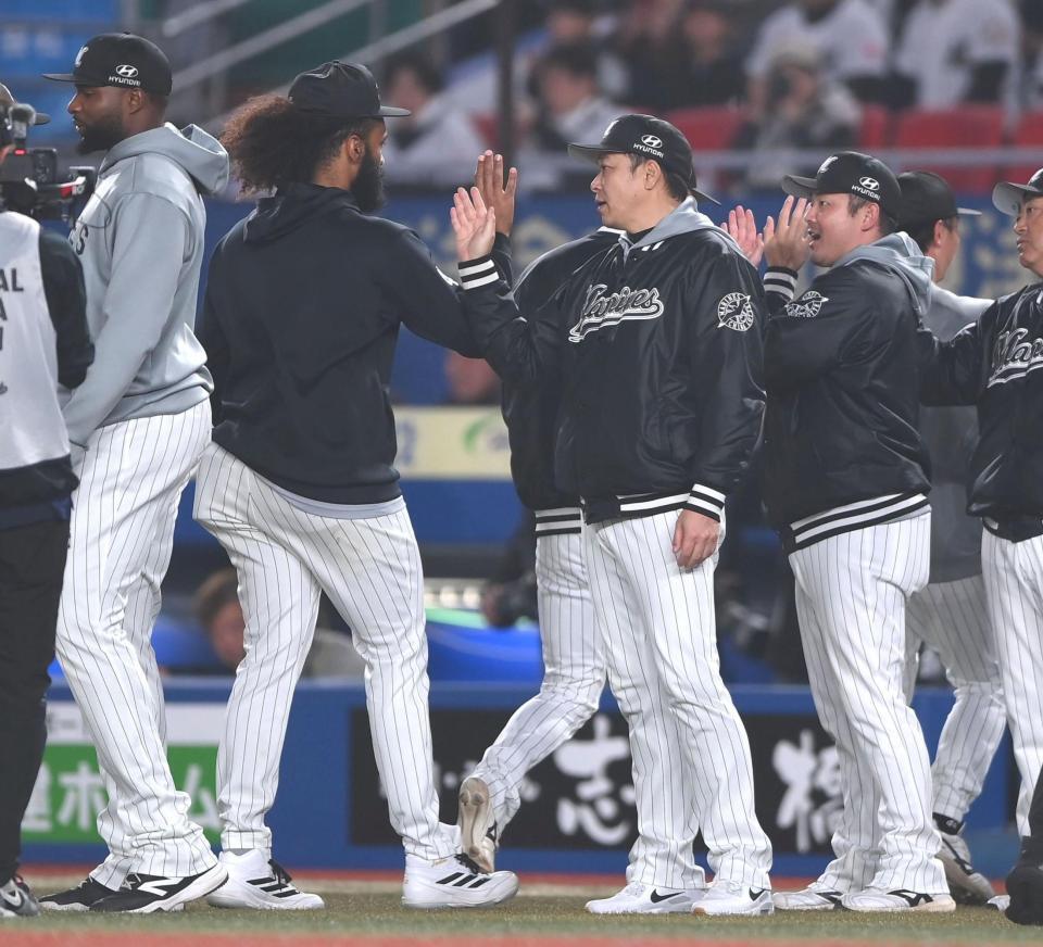 楽天の追撃をかわしジャクソン（左）らナインとタッチを交わすサブロー監督（撮影・開出牧）