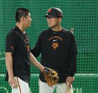 ヘルメットをかぶる川相コーチ（右）＝撮影・佐々木彰尚