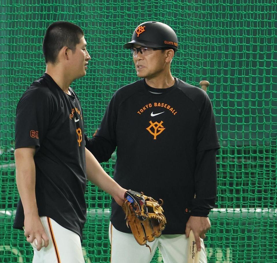 ヘルメットをかぶる川相コーチ（右）＝撮影・佐々木彰尚