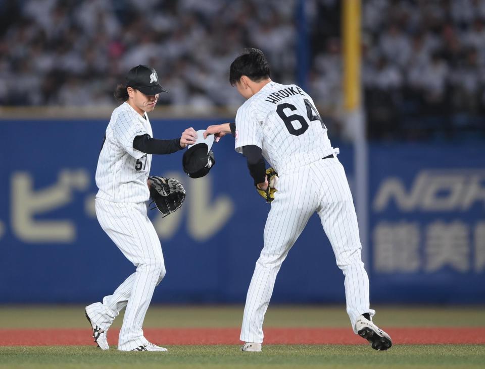 ３回、強風で飛ばされた帽子を二塁手の小川（左）から受け取る広池（撮影・開出牧）