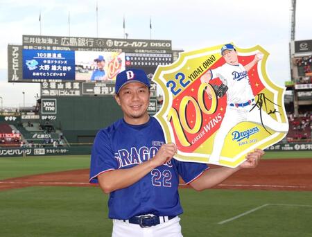 プロ通算１００勝を達成し、記念のボードを手に写真に納まる大野（撮影・北村雅宏）