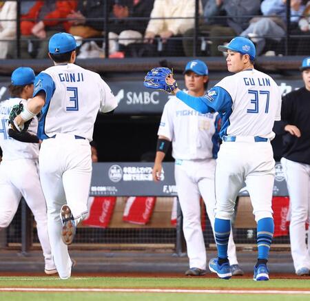 １回を抑え、郡司（左）とタッチを交わす古林（撮影・中島達哉）