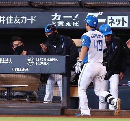 ９回、プロ初本塁打を放った大塚（４９）を迎える新庄監督（中央）＝撮影・中島達哉