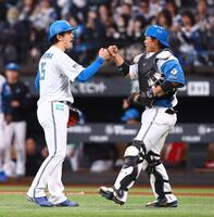 今季初完封勝利をあげ、進藤（右）とタッチを交わす北山（撮影・中島達哉）