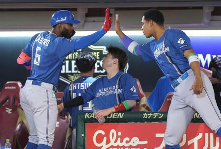 ７回、先制犠飛を放ち、万波（右）とタッチを交わすカストロ（撮影・西岡正）