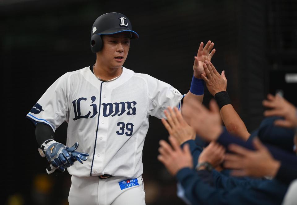 ２回、古賀悠の左越え適時二塁打で先制のホームを踏みナインとタッチを交わす平沢（撮影・開出牧）
