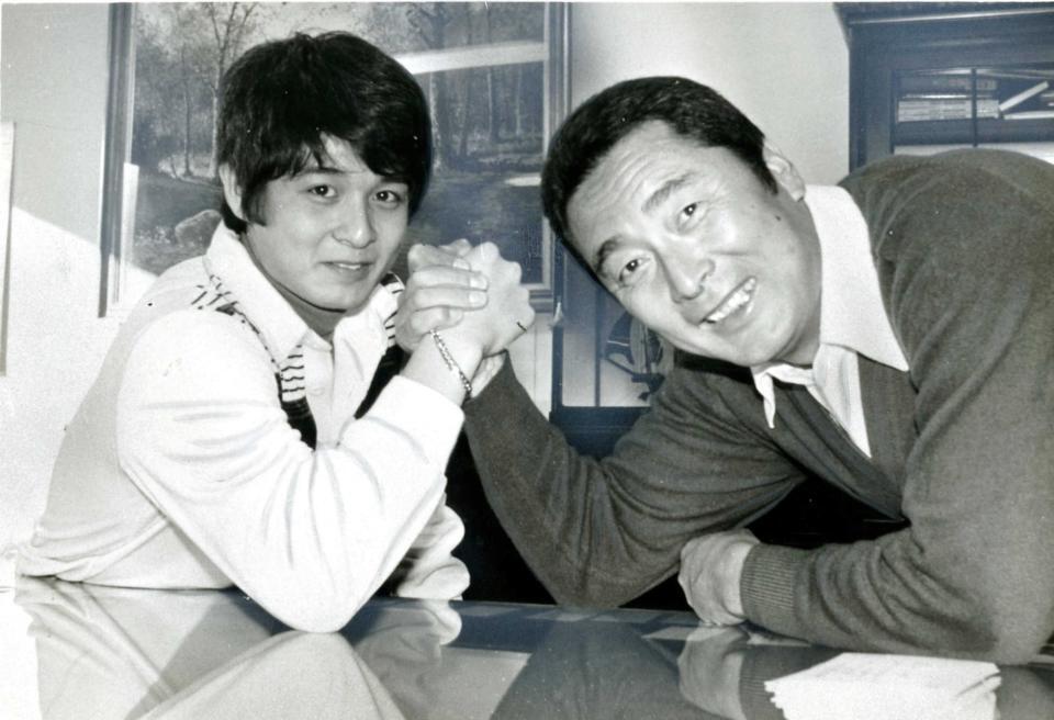 息子の金田賢一（左）と腕相撲をとる金田正一さん＝１９８０年
