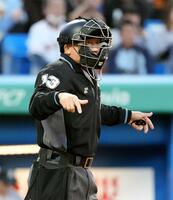 　安全対策でヘルメットをかぶり、試合に臨む審判員（共同）