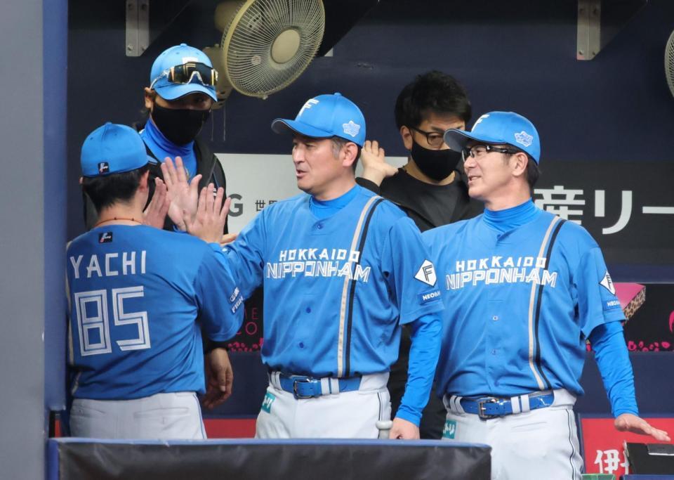 京セラドームでの連敗を止め、ベンチでタッチをかわす新庄監督ら（撮影・坂部計介）