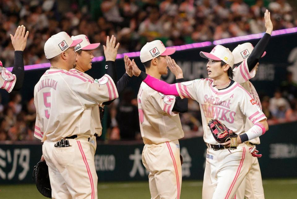 ロッテに勝利し、タッチを交わす周東（手前右）らソフトバンクナイン