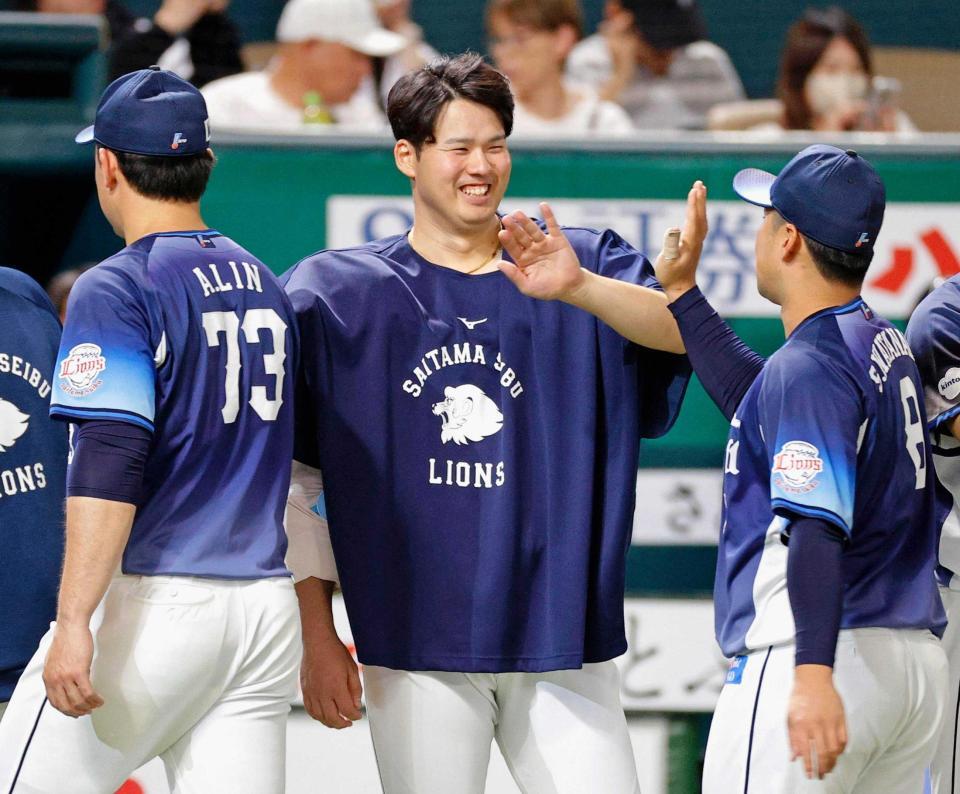　笑顔でナインを迎える渡辺（中央）