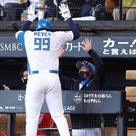 　８回、勝ち越しソロを放ったレイエス（９９）を迎える新庄監督（撮影・中島達哉）