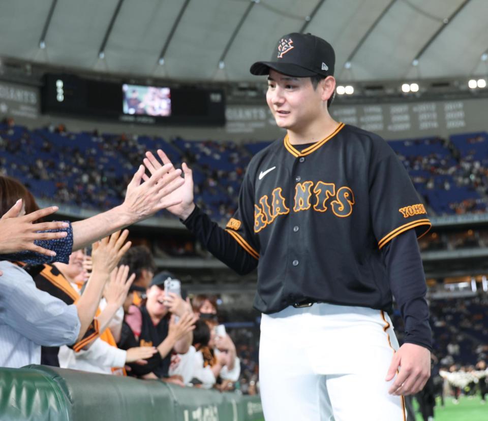 ５勝目を挙げファンとハイタッチの巨人・竹丸和幸＝東京ドーム（撮影・金田祐二）