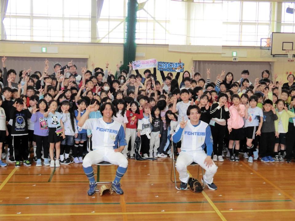 小学校を訪問し、笑顔で児童と記念撮影する日本ハムの田宮（右）と細川