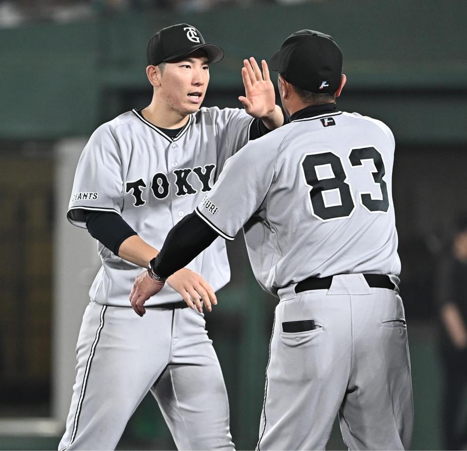 今季初勝利を挙げ阿部監督（右）とタッチを交わす戸郷（撮影・開出牧）