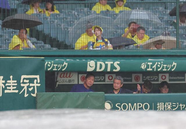 雨が降るグラウンドを見る井上監督（左）＝撮影・西田忠信