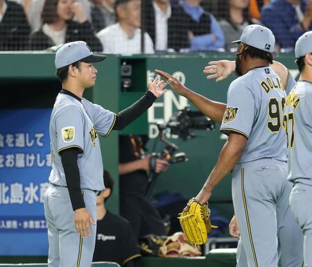 ８回を抑えたドリス（右）とハイタッチする高橋（撮影・伊藤笙子）