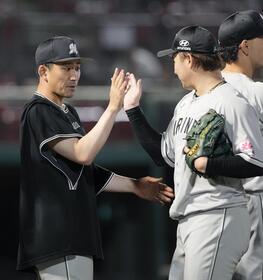 　今季初勝利を挙げ、14セーブ目の横山（右）を迎える小島