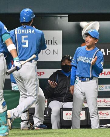 １回、左越えに先制の満塁本塁打を放った野村（左）を見つめる新庄監督（中央）