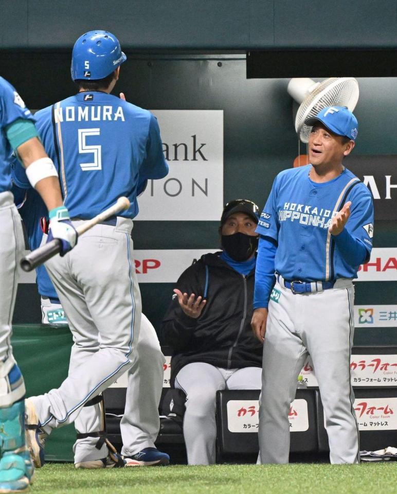 １回、左越えに先制の満塁本塁打を放った野村（左）を見つめる新庄監督（中央）
