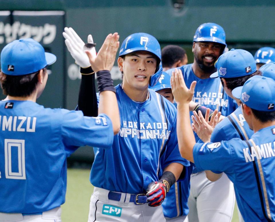 １回、先制の満塁本塁打を放ちナインに迎えられる野村