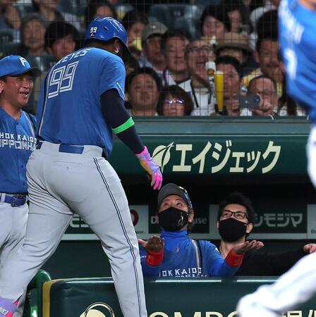 ６回、先制ソロのレイエス（左）を迎える新庄監督（撮影・西田忠信）