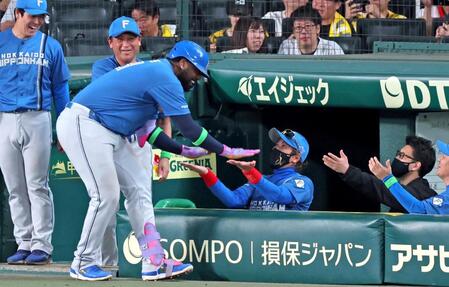６回、先制ソロを放ったレイエス（手前）とタッチを交わす新庄監督（撮影・立川洋一郎）