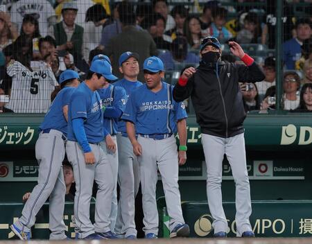 監督通算３００勝を達成し、ベンチ前でナインを待つ新庄監督（右）＝撮影・西田忠信