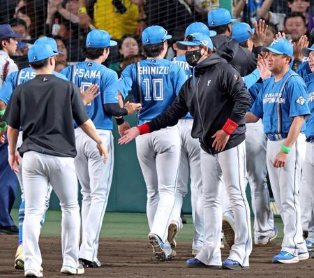 伊藤の完封勝利で監督通算３００勝目を飾りナインとタッチを交わす新庄監督（中央）＝撮影・立川洋一郎