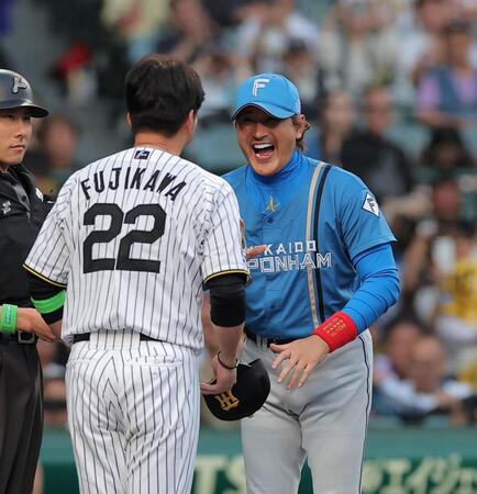 藤川監督（２２）とメンバー表の交換をする新庄監督（撮影・西田忠信）